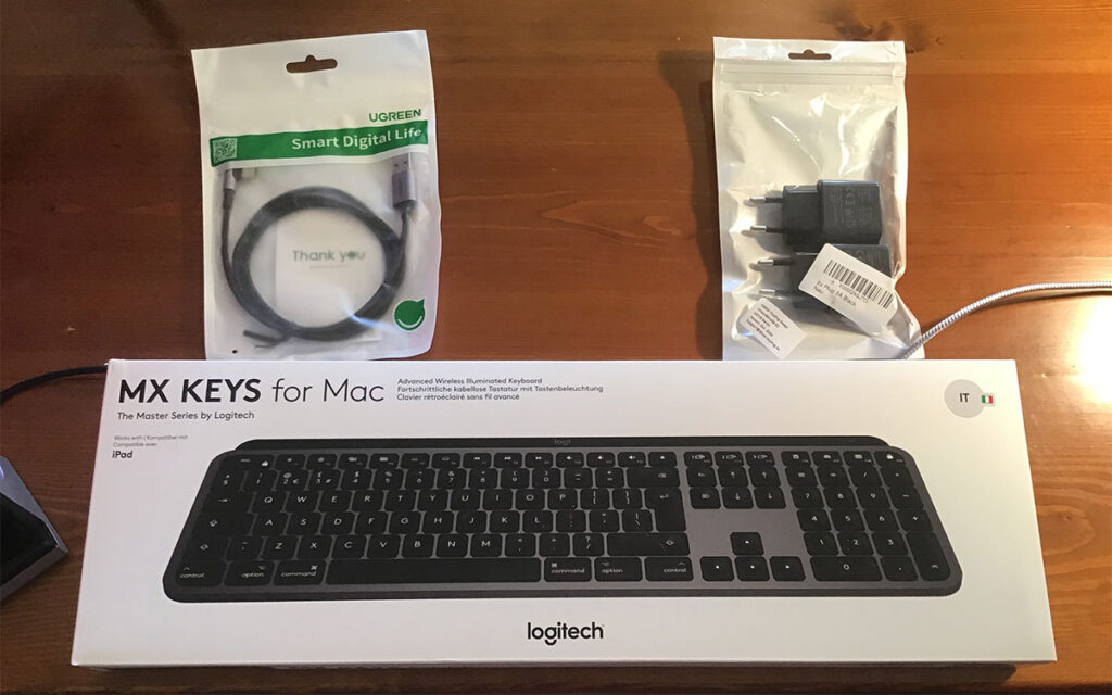 Disabili DOC – “Speciale Logitech MX Keys” – L'immagine mostra la tastiera “MX KEYS for Mac”, un cavo Ugreen USB A - USB-C con innesto angolato a 90º e degli alimentatori da 5V 2,4A